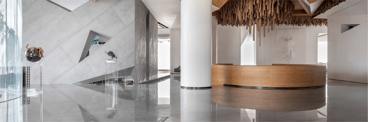 Hotel reception area with a curved wood desk and a sculptural ceiling