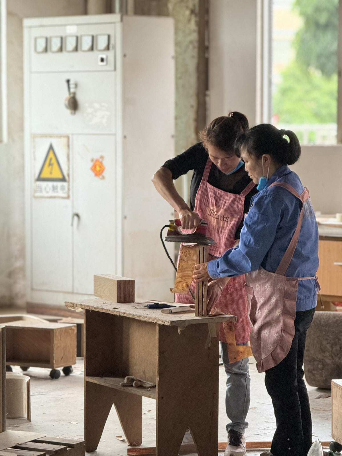 Factory staff performing surface work on a furniture component